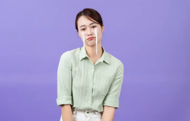 Mor arka planda genç bir Asyalı kadının fotoğrafı.