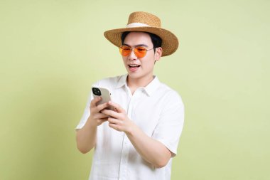 Yeşil arka plandaki genç Asyalı adamın fotoğrafı.