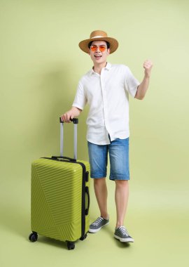 Yeşil arka plandaki genç Asyalı adamın fotoğrafı.