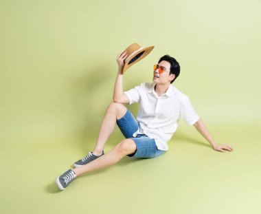 Yeşil arka plandaki genç Asyalı adamın fotoğrafı.