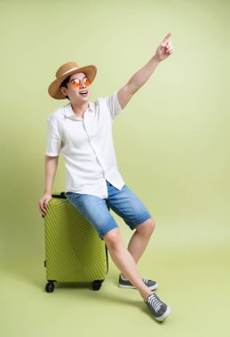 Yeşil arka plandaki genç Asyalı adamın fotoğrafı.