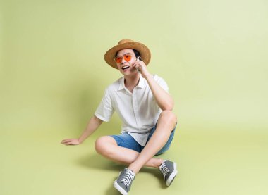 Yeşil arka plandaki genç Asyalı adamın fotoğrafı.