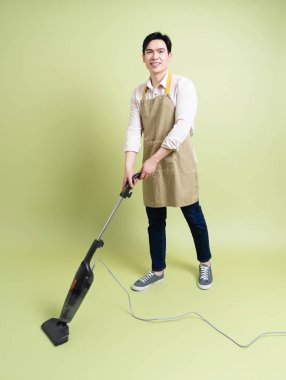 Yeşil arka plandaki genç Asyalı adamın fotoğrafı.