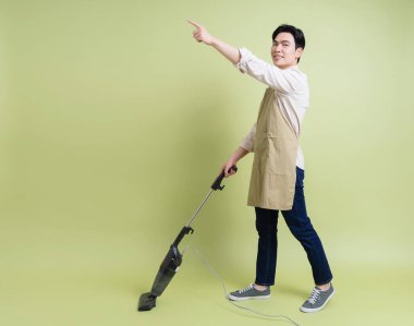 Yeşil arka plandaki genç Asyalı adamın fotoğrafı.