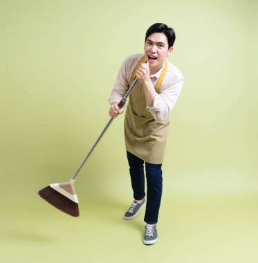 Yeşil arka plandaki genç Asyalı adamın fotoğrafı.