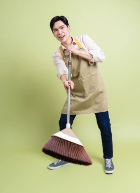 Yeşil arka plandaki genç Asyalı adamın fotoğrafı.