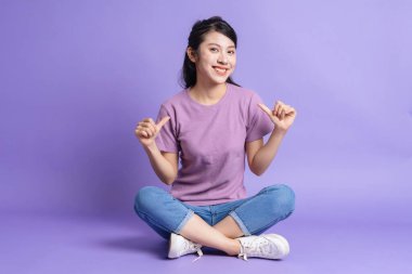 Photo of young Asian girl on purple background clipart