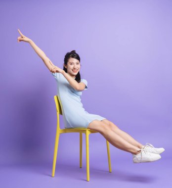 Mor arka planda genç bir Asyalı kızın fotoğrafı