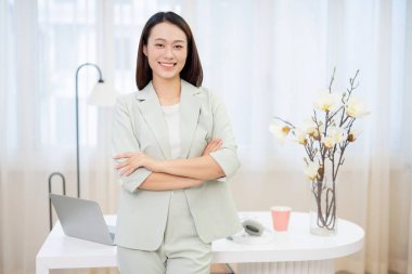 Genç Asyalı iş kadını ofiste çalışıyor.