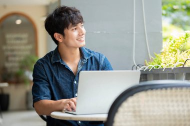 Kafedeki genç Asyalı adamın fotoğrafı.