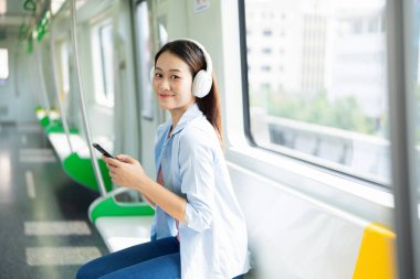 Metrodaki genç Asyalı kadının fotoğrafı.