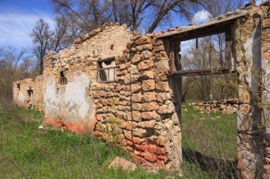 Güneşli bir günde eski bir evin kalıntıları. Taştan yapılmış bir yapının kalıntıları..
