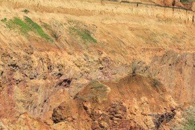 Yer çöküşünün kayalık kenarı. Yerdeki portakal kırmızısı kaya..