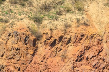 Yer çöküşünün kayalık kenarı. Yerdeki portakal kırmızısı kaya..