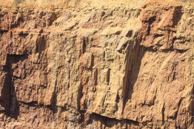 Yer çöküşünün kayalık kenarı. Yerdeki portakal kırmızısı kaya..