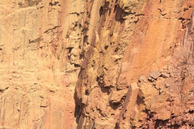 Yer çöküşünün kayalık kenarı. Yerdeki portakal kırmızısı kaya..