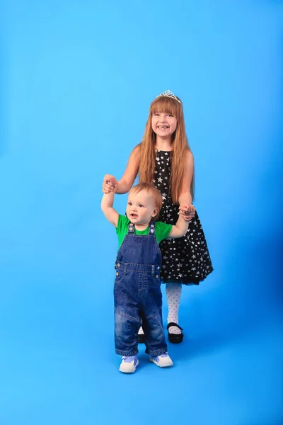 Ein Mädchen Hält Händchen Mit Einem Jungen Vor Blauem Hintergrund — Stockfoto