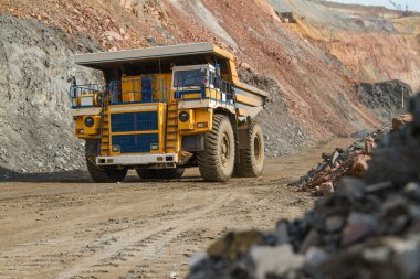 Large dump truck for removal of rock mass from the quarry for open-pit mining of minerals. Initial stage of metallurgy, machinery for the extraction of raw ore.