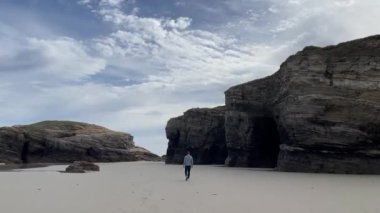 Denizin üzerinde gün batımı gelir, ve sahilde sakin bir gelgit.