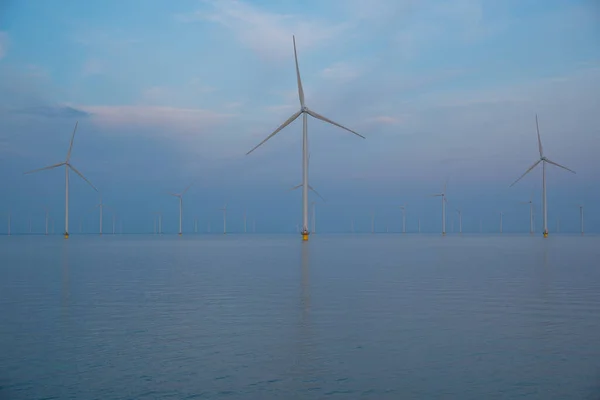 stock image wind power station in the north sea at sunset