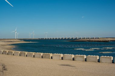 Deltawerk yakınlarında deniz kenarında rüzgar türbini.