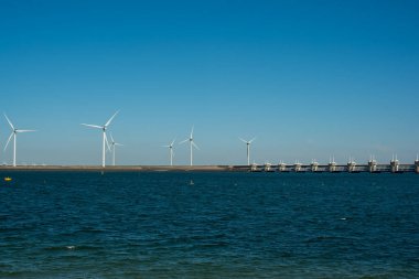 Deltawerk yakınlarında deniz kenarında rüzgar türbini.