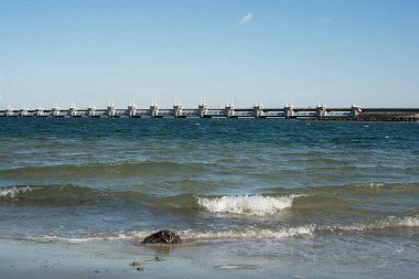 Deltawerk yakınlarında deniz kenarında rüzgar türbini.