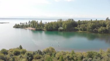 Çok güzel bir körfez manzarası, bir grup genç sörfçünün stand-up 'ta yelken açtığı bir yer. Bir grup sörfçünün üst görünümü.