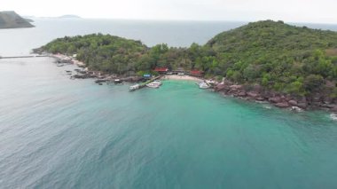 Phu Quoc, Vietnam açıklarındaki tropikal Xuong adasının manzaralı manzarası. Mavi göl, beyaz kumlu sahil, rıhtım ve lüks yatlar rüya gibi bir tatil ortamı yaratır..