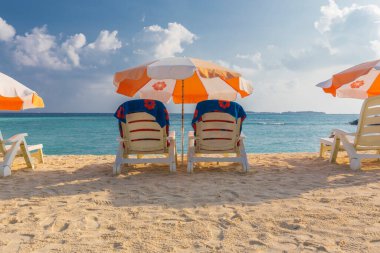 Plaj şemsiyesi ve kumsalda güneşlik.