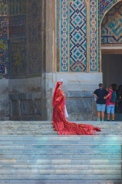 Semerkand, Özbekistan - Ekim. - 10. 2024: Özbekistan 'ın ulusal kostümlü bir kız medresenin girişinin önünde