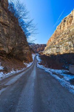 Road to the mountains through the gorge in winter clipart