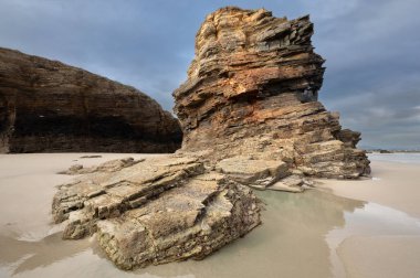 Geological rock formations on Playa de Las Catedrales (Beach of the Cathedrals), Galicia, Spain clipart