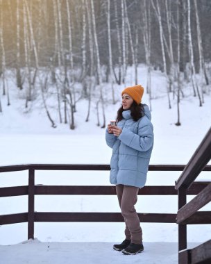 Kış manzarasında bir fincan sıcak içecekle bir kadın. Yüksek kalite fotoğraf