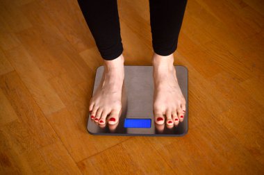 Banyo terazisinde kırmızı tırnak cilası olan kadın ayakları. Yüksek kalite fotoğraf