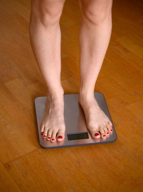 Banyo terazisinde kırmızı ojeli kadın ayakları. Yüksek kalite fotoğraf