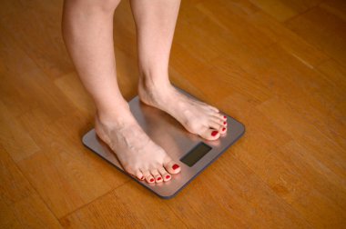 Banyo terazisinde kırmızı ojeli kadın ayakları. Yüksek kalite fotoğraf