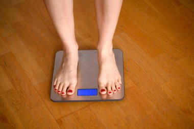 Banyo terazisinde kırmızı ojeli kadın ayakları. Yüksek kalite fotoğraf