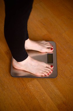 Banyo terazisinde kırmızı ojeli kadın ayakları. Yüksek kalite fotoğraf