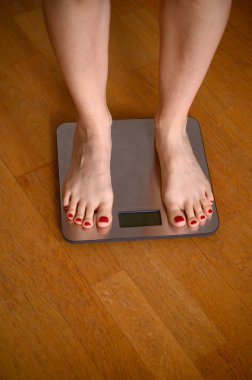 Banyo terazisinde kırmızı ojeli kadın ayakları. Yüksek kalite fotoğraf