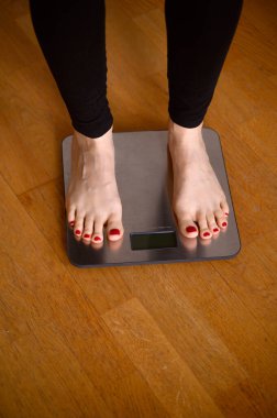 Banyo terazisinde kırmızı ojeli kadın ayakları. Yüksek kalite fotoğraf