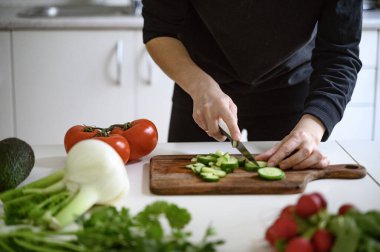 Sağlıklı yemek ya da salata hazırlıyorum. Masada taze sebzeler ve bitkiler var. Yüksek kalite fotoğraf