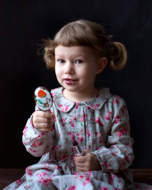 Aynalı ve rujlu küçük bir kız. Yüksek kalite fotoğraf