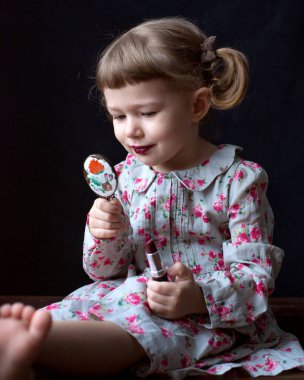 Aynalı ve rujlu küçük bir kız. Yüksek kalite fotoğraf