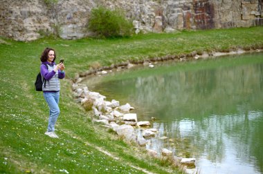 Skrylle doğal koruma alanı olan Lund Skane İsveç 'te göl fotoğrafı çeken bir kadın turist. Yüksek kalite fotoğraf