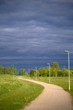 Yazın kırsal bir yol ve gökyüzünde kara gök gürültüsü bulutları. Bakış açısı. Yüksek kalite fotoğraf
