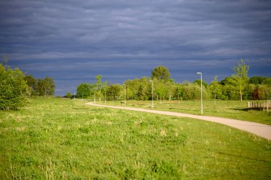 Yazın kırsal bir yol ve gökyüzünde kara gök gürültüsü bulutları. Bakış açısı. Yüksek kalite fotoğraf