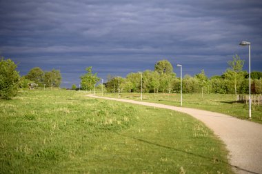 Yazın kırsal bir yol ve gökyüzünde kara gök gürültüsü bulutları. Bakış açısı. Yüksek kalite fotoğraf