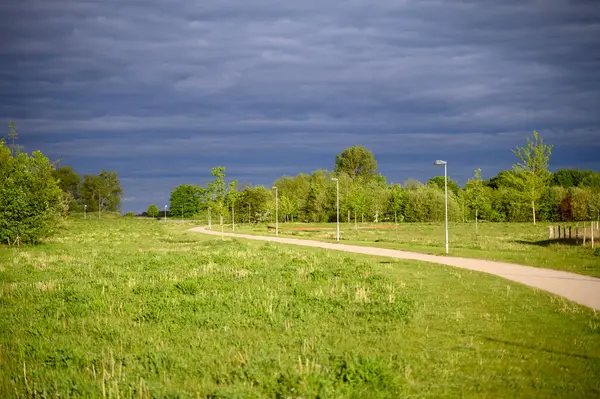 Yazın kırsal bir yol ve gökyüzünde kara gök gürültüsü bulutları. Bakış açısı. Yüksek kalite fotoğraf