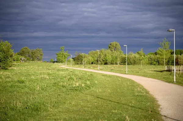 Yazın kırsal bir yol ve gökyüzünde kara gök gürültüsü bulutları. Bakış açısı. Yüksek kalite fotoğraf